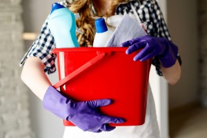 Close-up of woman's hands holding bucket full of cleaners